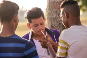 Group Of Teenagers Boy Smoking Cigarette With Friends